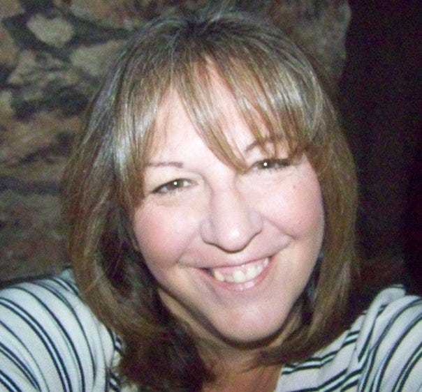 A young brunette woman with straight hair and a warm smile