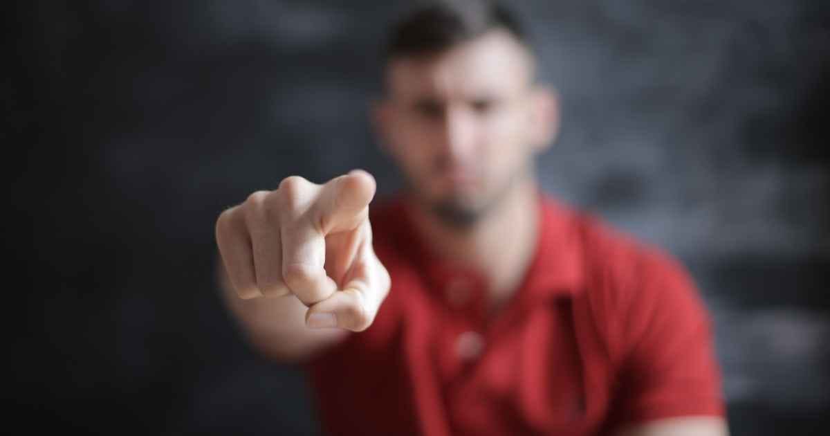 Blurred man pointing forward, emphasizing index finger close-up Blurred man pointing forward, emphasizing index finger close-up