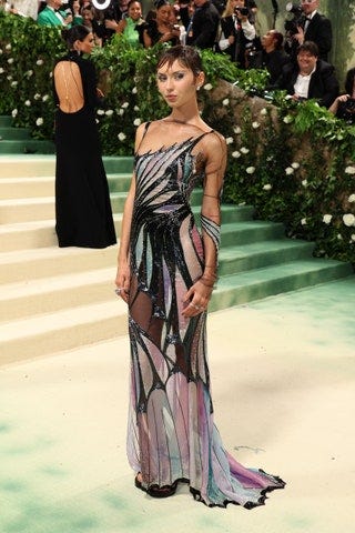 Image may contain Clothing Dress Formal Wear Adult Person Evening Dress Fashion Accessories Tie Bag and Handbag