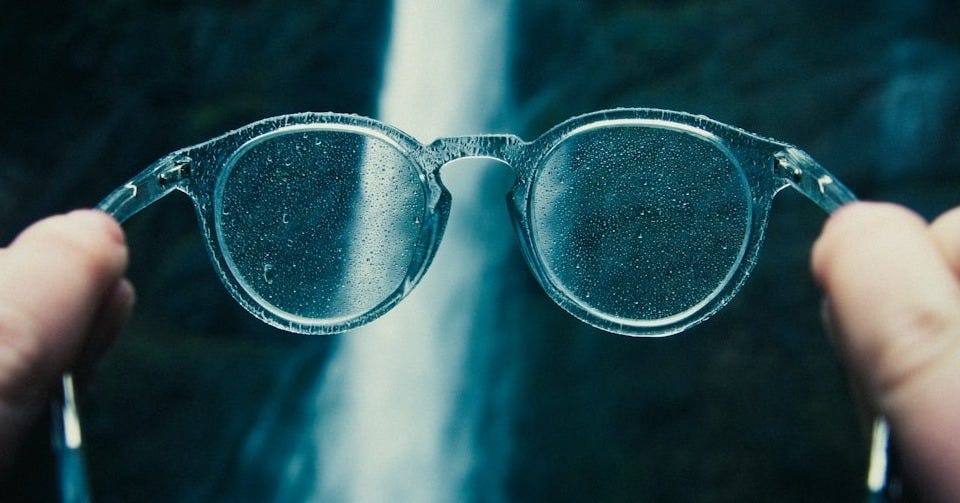 person holding eyeglasses person holding eyeglasses