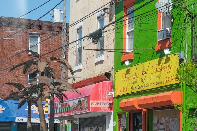 Metal palm trees in front of colorful rowhome storefronts