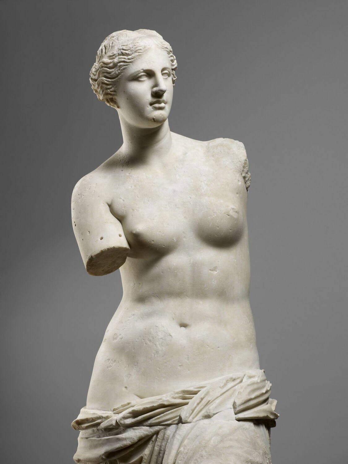 Upper half of the Venus de Milo photographed separately, showing the torso and head of the statue without its arms. Upper half of the Venus de Milo photographed separately, showing the torso and head of the statue without its arms.