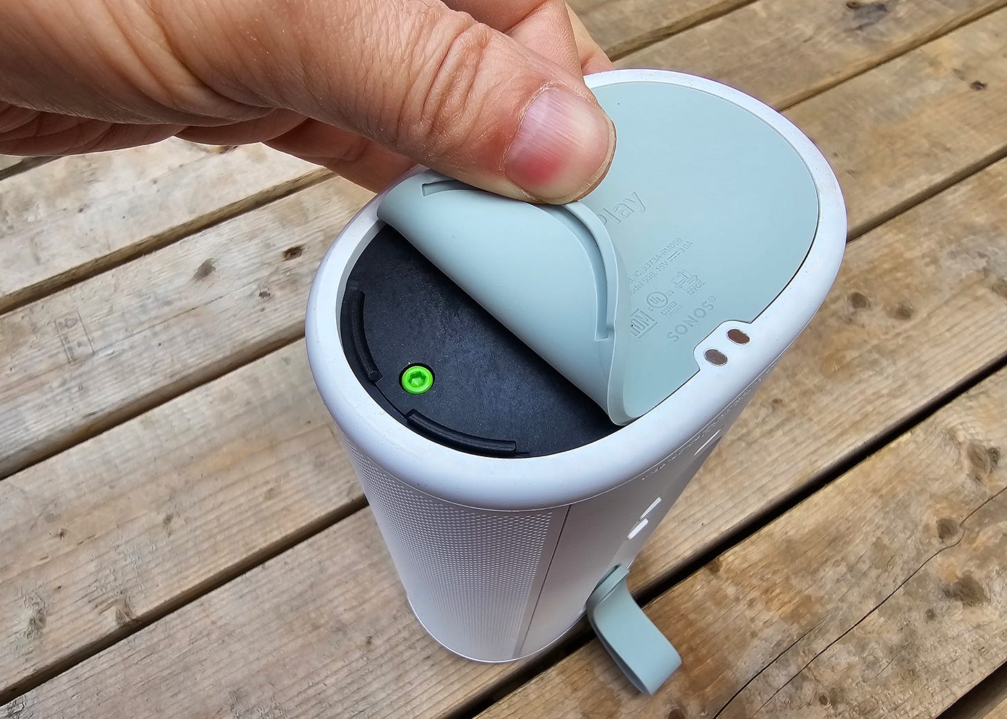 An upside-down Sonos Play with its rubber seal pulled back to reveal the user-replaceable battery. An upside-down Sonos Play with its rubber seal pulled back to reveal the user-replaceable battery.