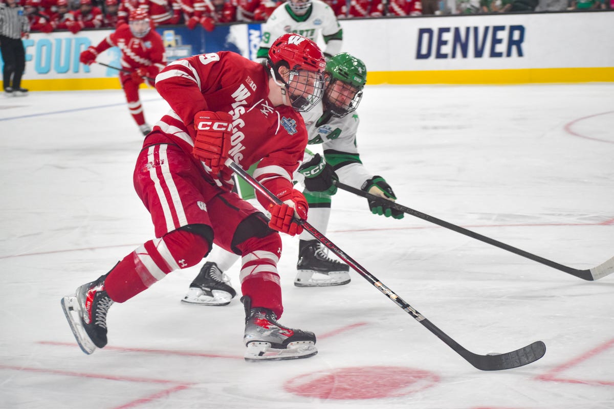 Quinn Finley protects the puck on his backhand while skating on the right faceoff dot
