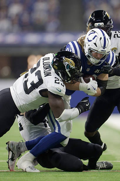 Tyler Warren of the Indianapolis Colts is tackled by Foye Oluokun of the Jacksonville Jaguars in the first quarter of the game at Lucas Oil Stadium...