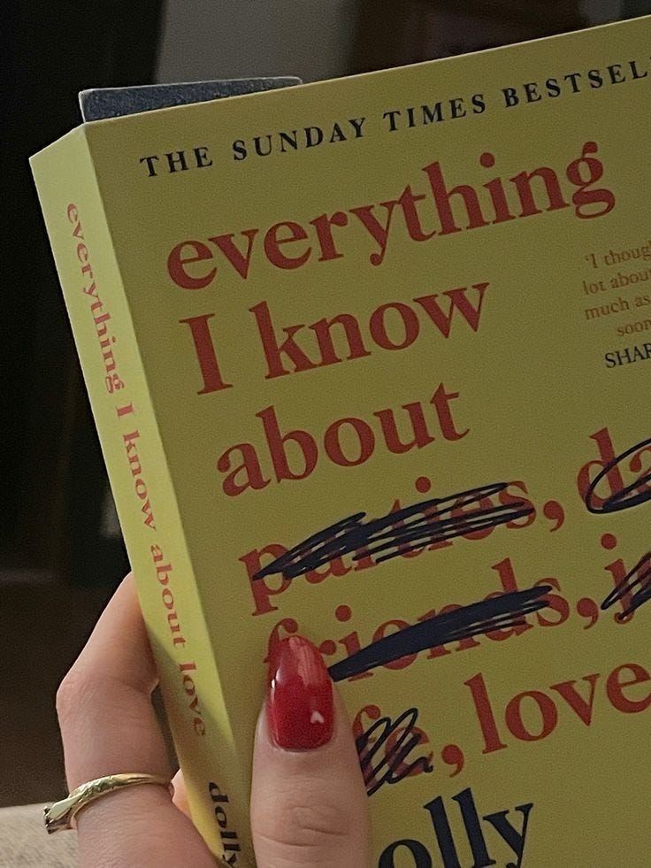 This may contain: a woman's hand holding up a book about everything i know about love and life