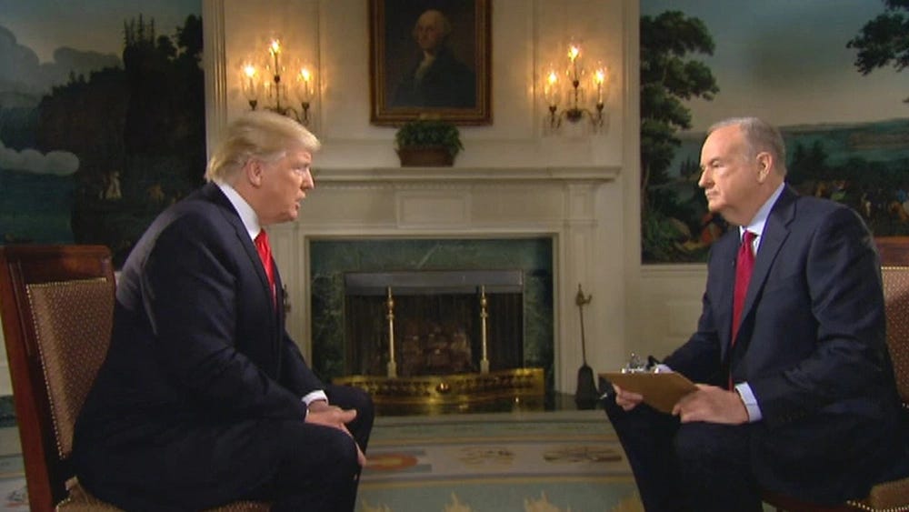 Donald Trump and Bill O'Reilly face each other, sitting in chairs. They're in a fancy room in the White House with a marble fireplace, murals, and a portrait of George Washington in the background. Donald Trump and Bill O'Reilly face each other, sitting in chairs. They're in a fancy room in the White House with a marble fireplace, murals, and a portrait of George Washington in the background.