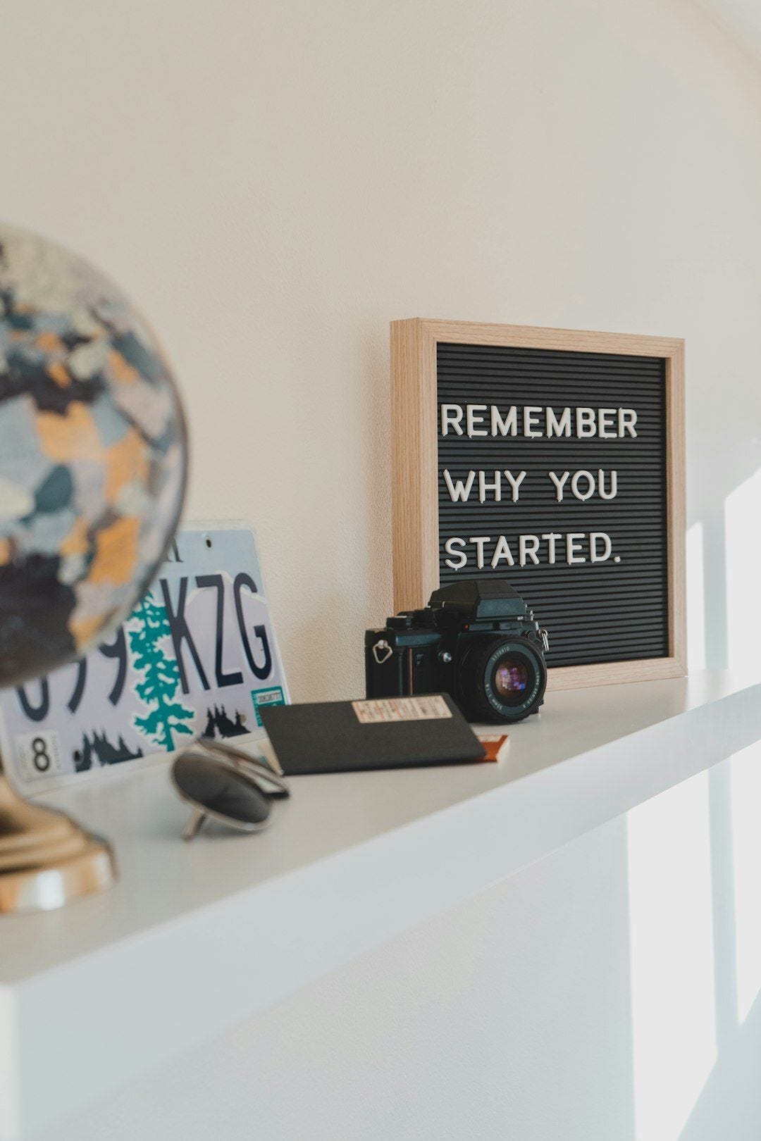 shallow focus photo of black SLR camera on white wooden shelf shallow focus photo of black SLR camera on white wooden shelf