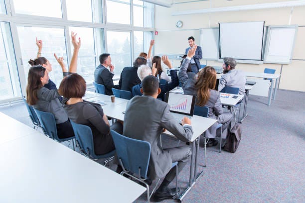 Business people in a classroom listening lecturer Business people in a classroom listening lecturer