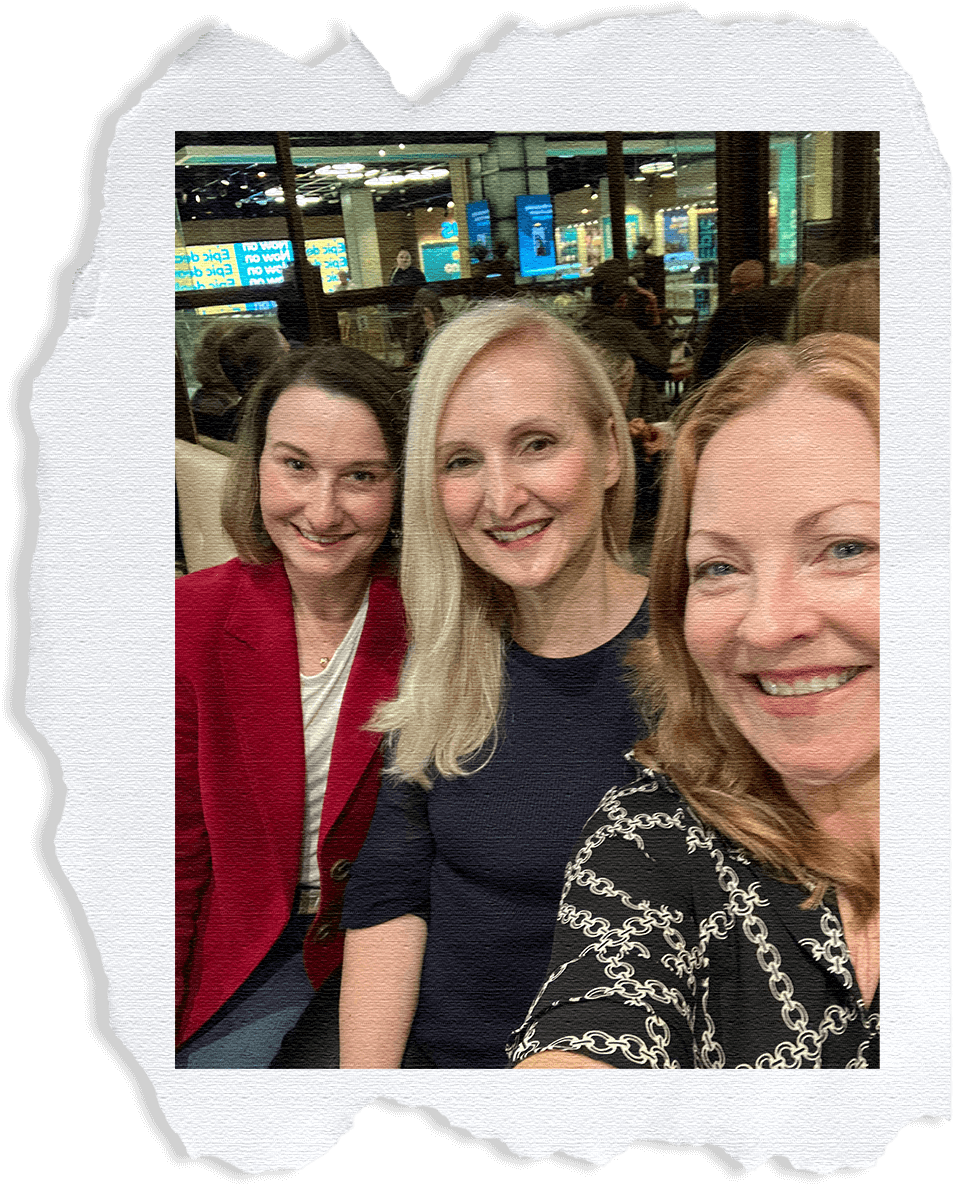Photo pressed onto a ripped piece of paper: Image of Kyra Geddes, Belinda Alexandra and Jane Tara with their heads together smiling.