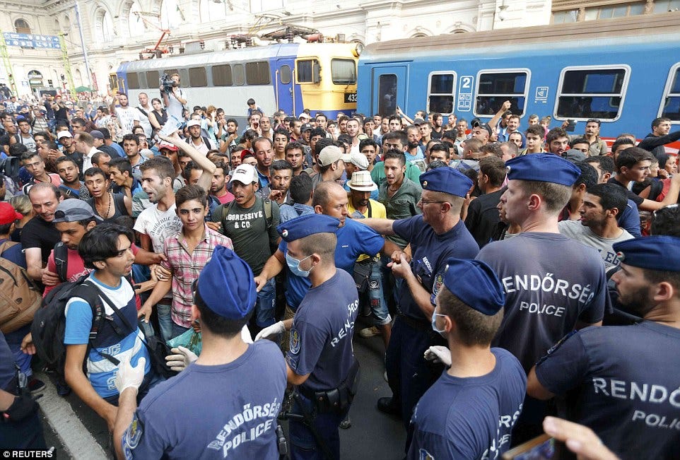 Clashes: Migrants and police pictured at the railway station in Budapest, Hungary, after people were told to leave and it was closed Clashes: Migrants and police pictured at the railway station in Budapest, Hungary, after people were told to leave and it was closed