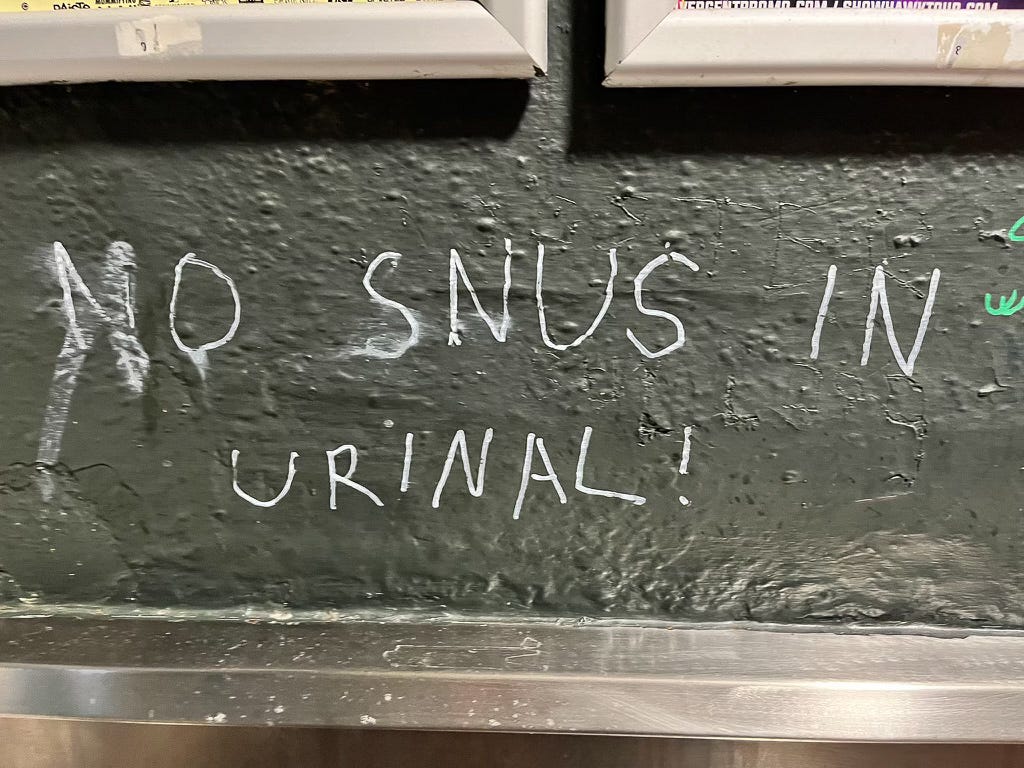 Grafitti on the walls of the men's toilet, which reads: "No snus in urinal!"