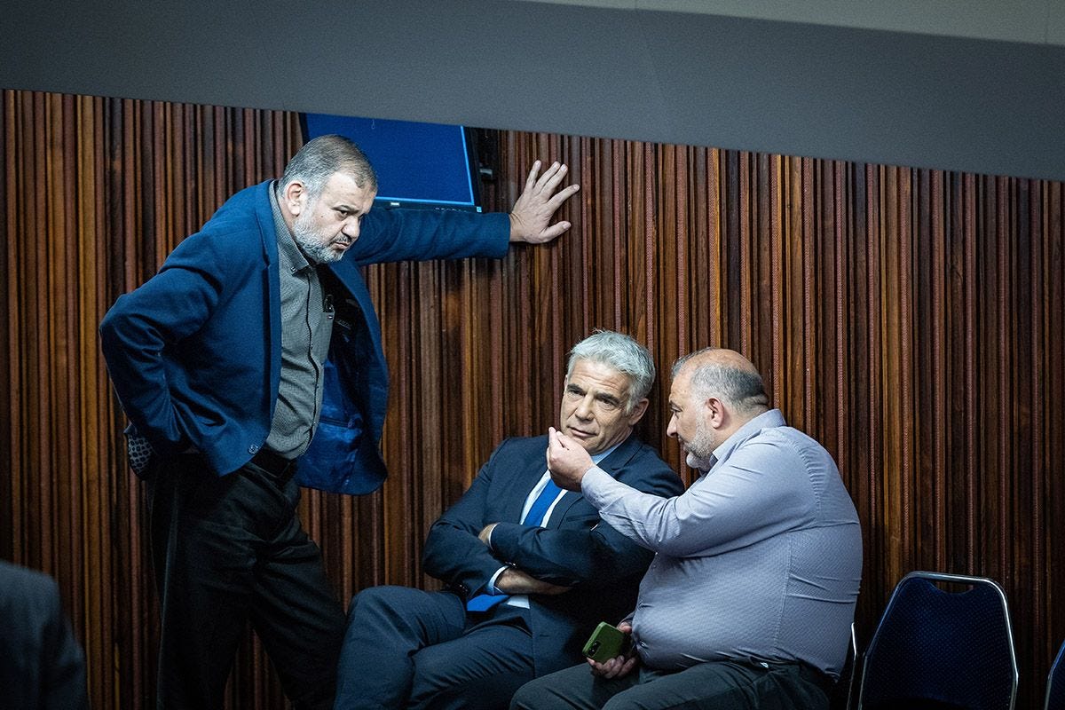 Ra'am (United Arab List) Party Chairman MK Mansour Abbas speaks with Israeli Foreign Minister Yair Lapid and MK Walid Taha during a plenum session in the assembly hall of the Knesset, the Israeli parliament, in Jerusalem on May 23, 2022. (Photo by Yonatan Sindel/Flash90) Ra'am (United Arab List) Party Chairman MK Mansour Abbas speaks with Israeli Foreign Minister Yair Lapid and MK Walid Taha during a plenum session in the assembly hall of the Knesset, the Israeli parliament, in Jerusalem on May 23, 2022. (Photo by Yonatan Sindel/Flash90)