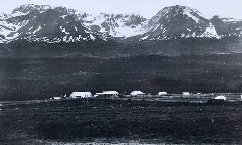A British missionary family, an indigenous Yahgan family, and houses with fences overshadowed by mountains