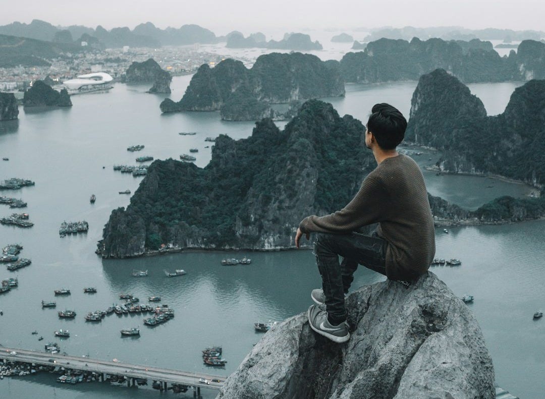 man sitting on cliff man sitting on cliff