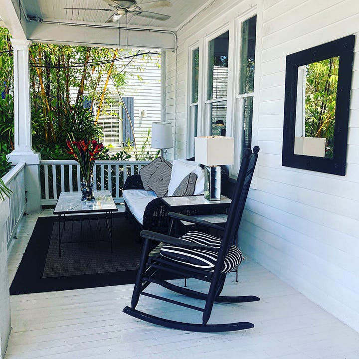 Weatherboard verandah with rocking chairs.