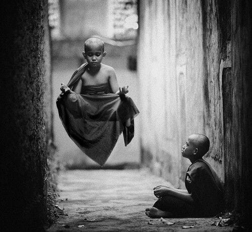 This may contain: a man sitting on the ground next to a little boy with a towel over his head This may contain: a man sitting on the ground next to a little boy with a towel over his head