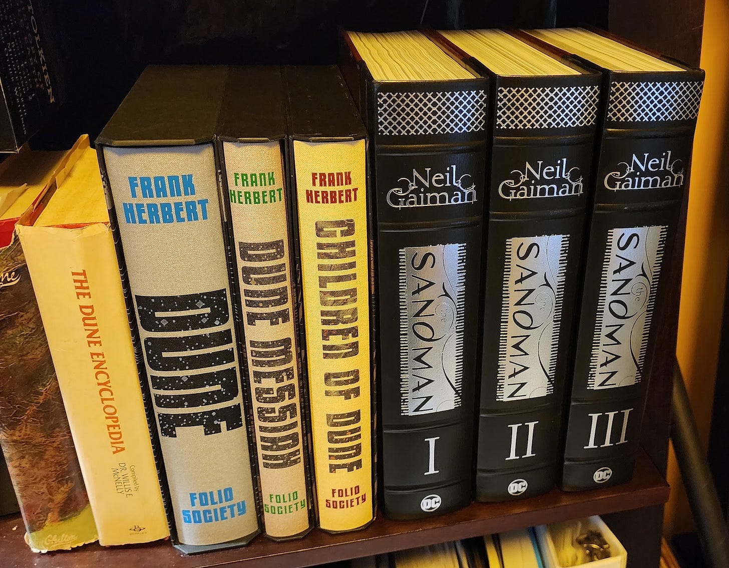 Nala's copies of The Dune Encyclopedia, the Folio Society's first 3 Dune novels, and the 3 Volumes of the The Sandman Omnibus