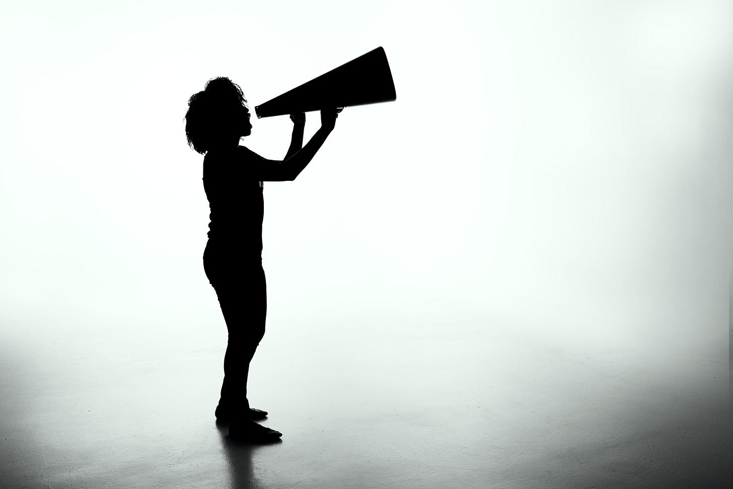 silhouette of someone shouting into a megaphone silhouette of someone shouting into a megaphone