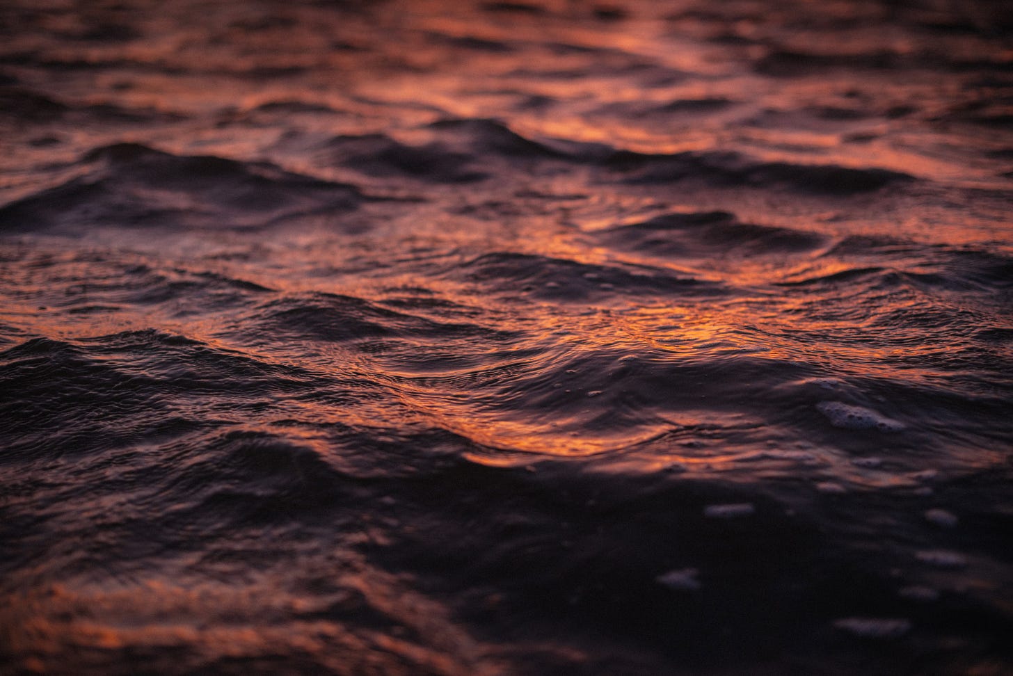 Sunrise colours reflected in the choppy waves of the River Mersey