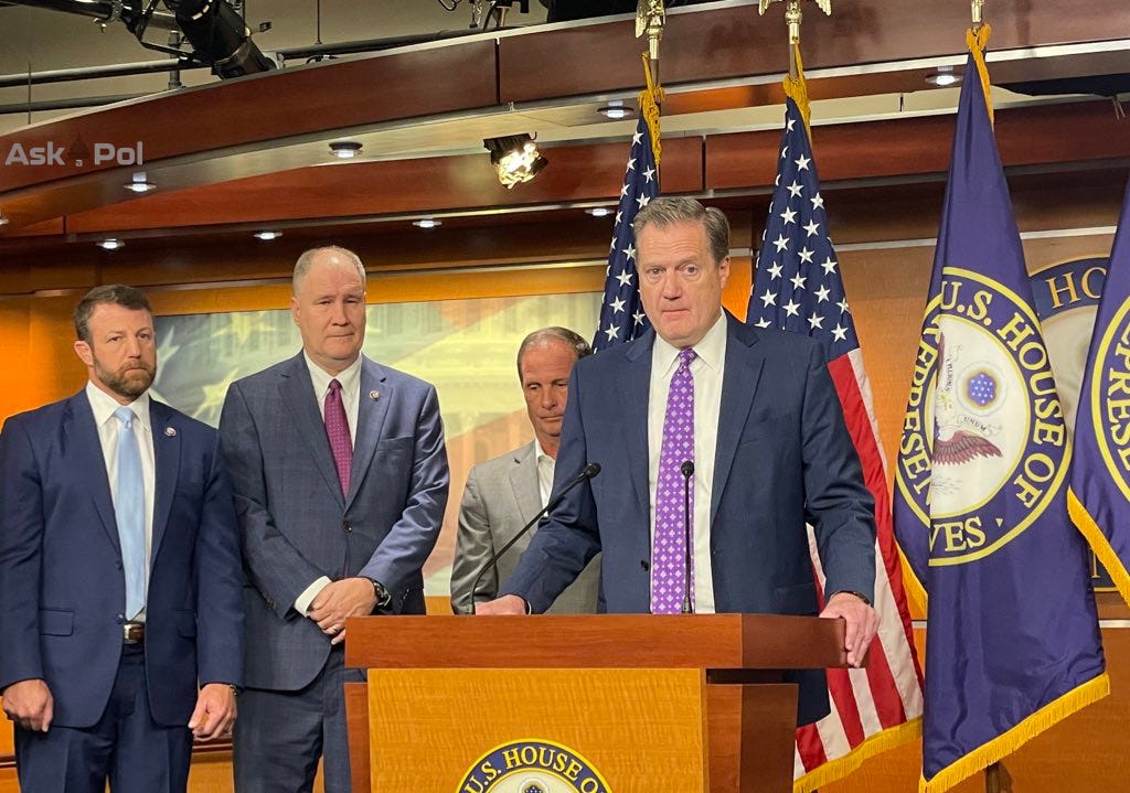 Politicians in suits stand on a stage in front of a big House of Representatives podium as they answer questions from Congressional press corps Politicians in suits stand on a stage in front of a big House of Representatives podium as they answer questions from Congressional press corps