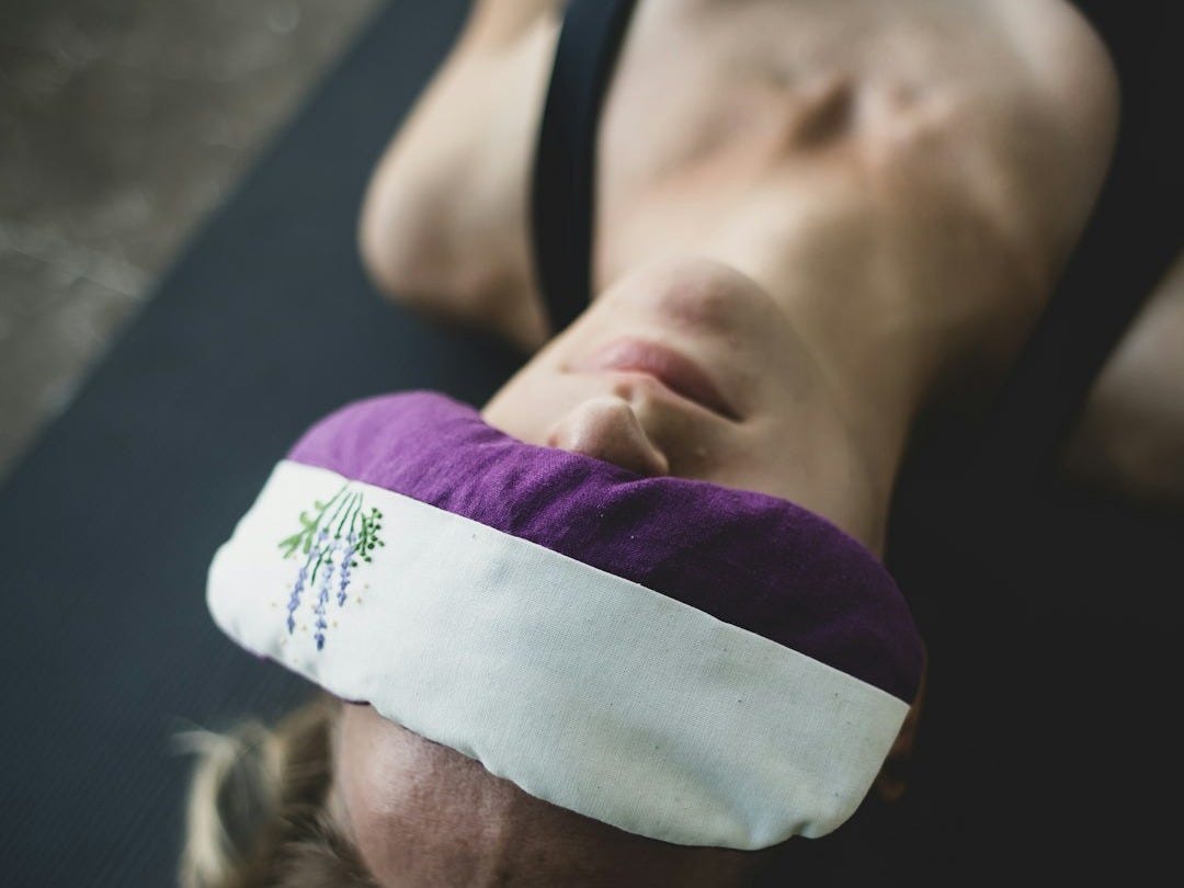 woman put purple and white pad on her forehead woman put purple and white pad on her forehead