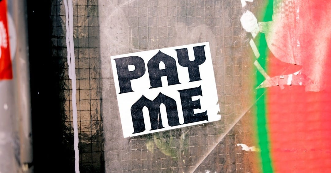 a pay me sticker on the side of a building