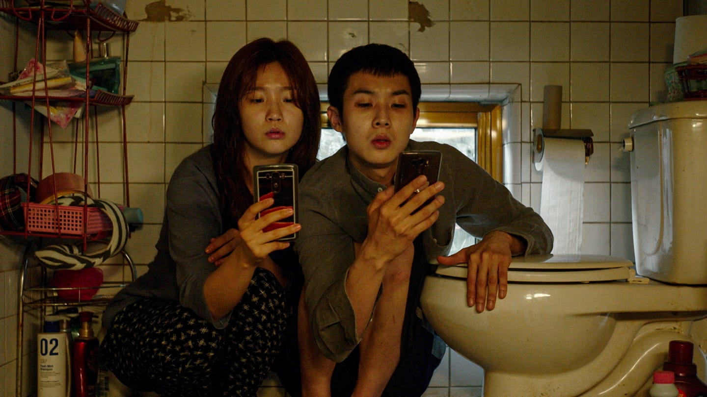 A close-up from Parasite (2019) in a dimly lit bathroom: muted yellow and green tones underscore the gritty textures of tile and skin. The scene captures faces partially obscured by shadows, conveying a sense of quiet desperation, layered tension, and the unspoken cost of maintaining appearances. A close-up from Parasite (2019) in a dimly lit bathroom: muted yellow and green tones underscore the gritty textures of tile and skin. The scene captures faces partially obscured by shadows, conveying a sense of quiet desperation, layered tension, and the unspoken cost of maintaining appearances.