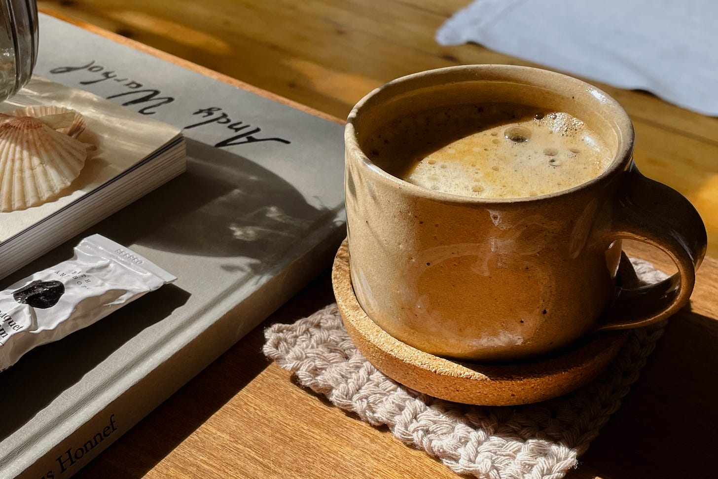 Close-up of a coffee mug filled with freshly brewed coffee in warm sunshine.
