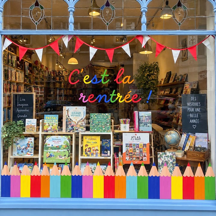 Left, a French bookshop window decorated for la rentrée with rainbow lettering and giant colored pencils along the base. Right, the school supply aisle at E.Leclerc, stacked with colored pencils, felt tips and BIC pens under a "rentrée" banner.