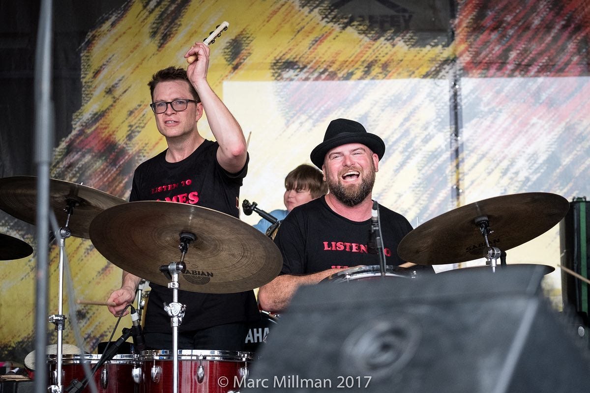May be an image of 2 people, people playing musical instruments, people standing, cymbal, indoor and text that says 'VES LISTEN AHA Marc Millman 2017'