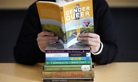 FILE - Amanda Darrow, director of youth, family and education programs at the Utah Pride Center, poses with books that have been the subject of complaints from parents in recent weeks on Thursday, Dec. 16, 2021, in Salt Lake City. A judge in Virginia dismissed a lawsuit Tuesday, Aug. 30, 2022, that sought to declare two books as obscene for children and to restrict their distribution to minors, including by booksellers and libraries. The books in question were “Gender Queer: A Memoir” by Maia Kobabe and “A Court of Mist and Fury” by Sarah J. Maas. (AP Photo/Rick Bowmer)