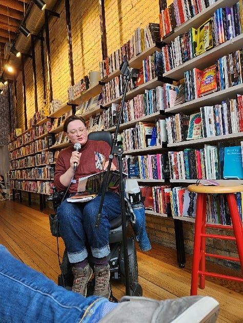 Various poets standing or sitting in Milkweed Bookstore, in front of filled bookcases, reading poetry.