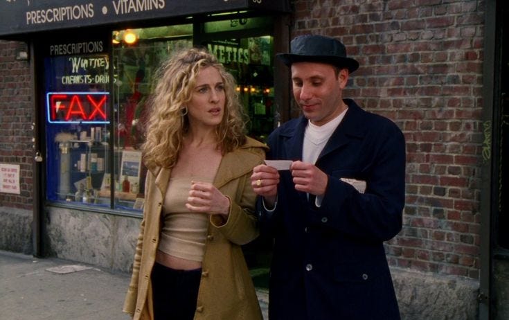 This may contain: a man standing next to a woman in front of a store holding a piece of paper