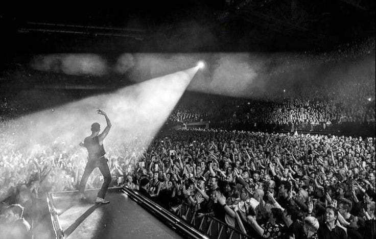 This may contain: a man standing on top of a stage in front of a crowd