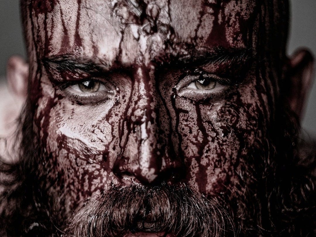 a close up of a man with blood on his face a close up of a man with blood on his face