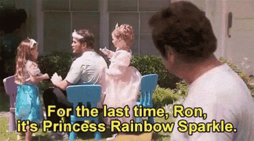 a man is standing in front of two little girls dressed as princesses