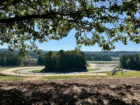 an artist doing a large live sketch of a concept bike; the race track; vintage bikes, and a cigar