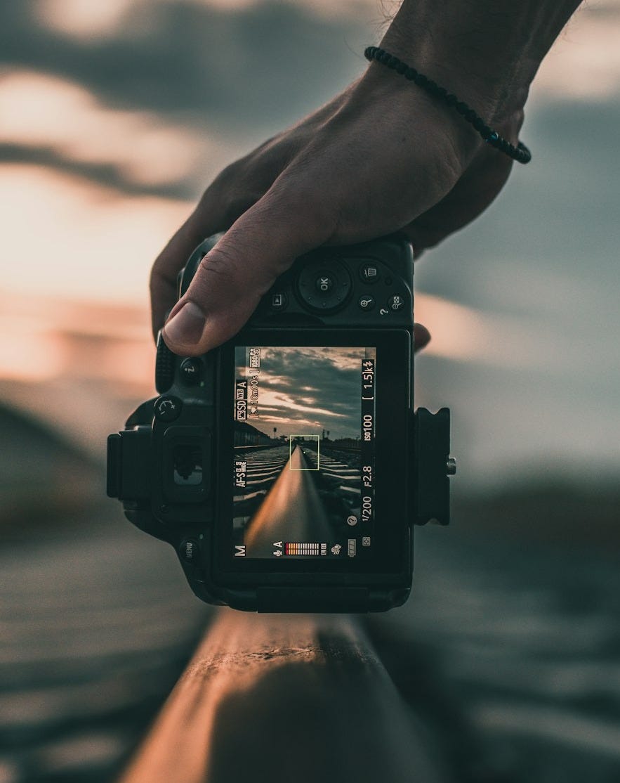 person holding black dslr camera during daytime person holding black dslr camera during daytime