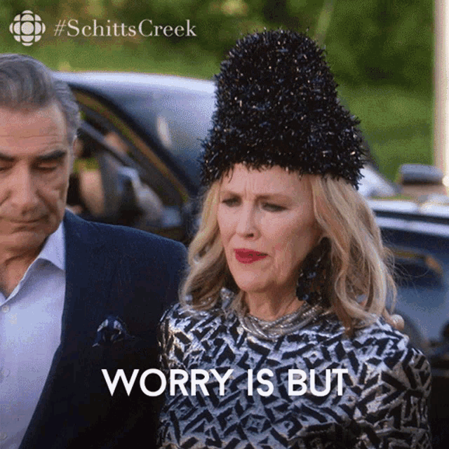 a woman in a black hat says worry is but in front of a man in a suit a woman in a black hat says worry is but in front of a man in a suit