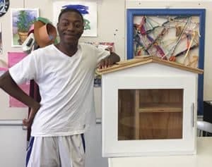 Artist Wayne Pace poses next to a Little Free Library before painting it as part of the Little Library Prize competition at the 2017 Michigan State Fair. <span class="credit">Photo: Detroit Little Libraries</span> Artist Wayne Pace poses next to a Little Free Library before painting it as part of the Little Library Prize competition at the 2017 Michigan State Fair. <span class="credit">Photo: Detroit Little Libraries</span>