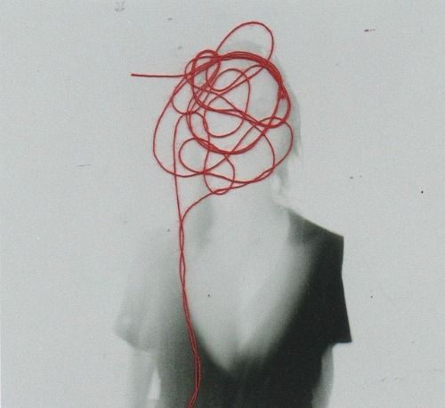 This may contain: a woman with red string attached to her back in black and white photo by person