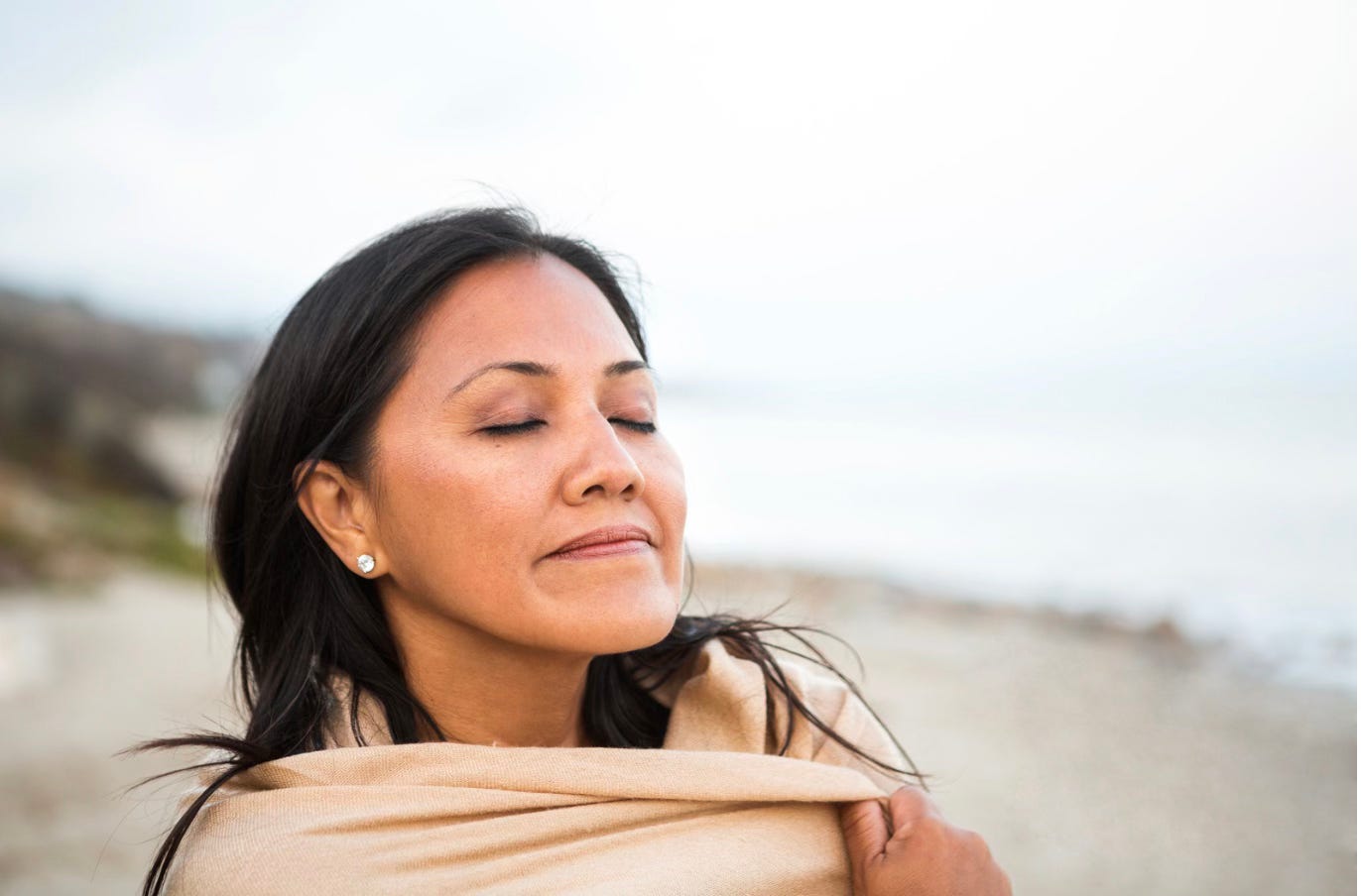 Woman dark hair on beach eyes closed