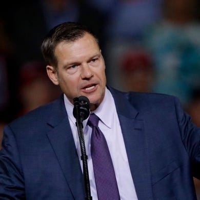 A person in a suit speaking into a microphone

Description automatically generated