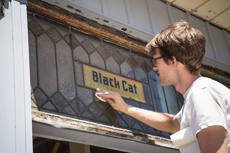 revealing the old hand painted sign at Black Cat Artspace