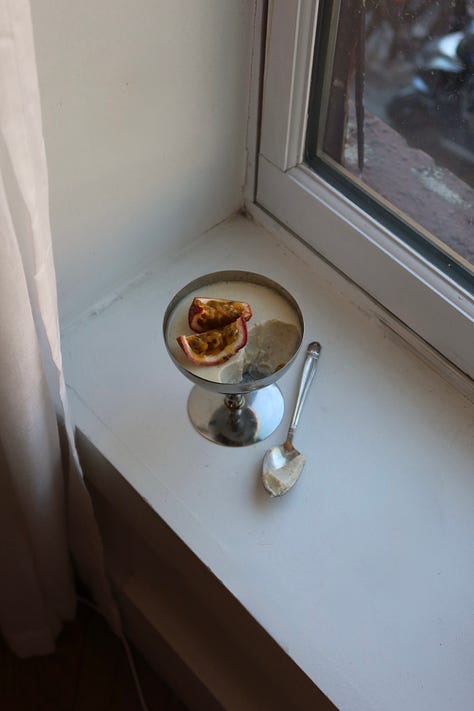 vanilla bean panna cotta in silver coupe glass with passion fruit on top 