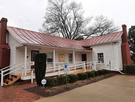 Exterior photos of the Country Doctor Museum, showing a yellow building with red room, a bench outside with the words Country Doctor Museum, and an original country doctor building.