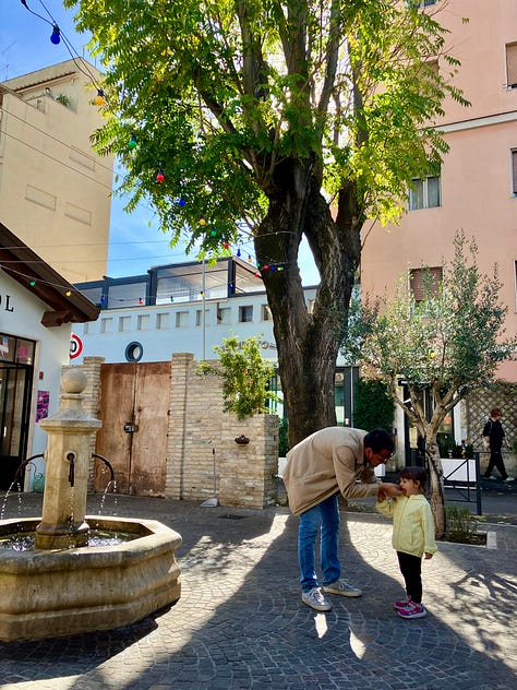 Serie di tre immagini: una crostata fatta in casa con intreccio di pasta frolla, una persona con una bambina che cammina in una piazza alberata con fontana, e un’illustrazione di una bambina che decora un albero di Natale.