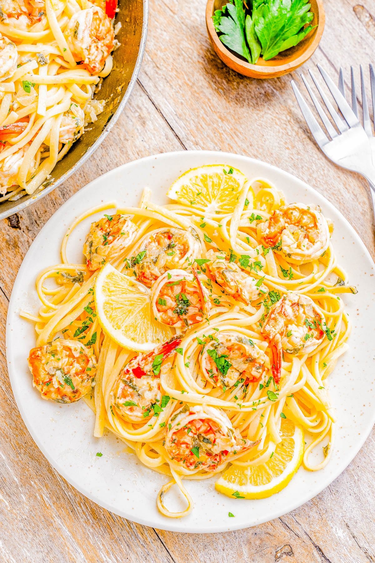 Shrimp Scampi Pasta on a plate with lemon wedges. 