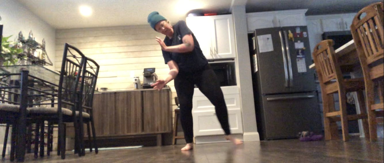 A person dances in a kitchen.